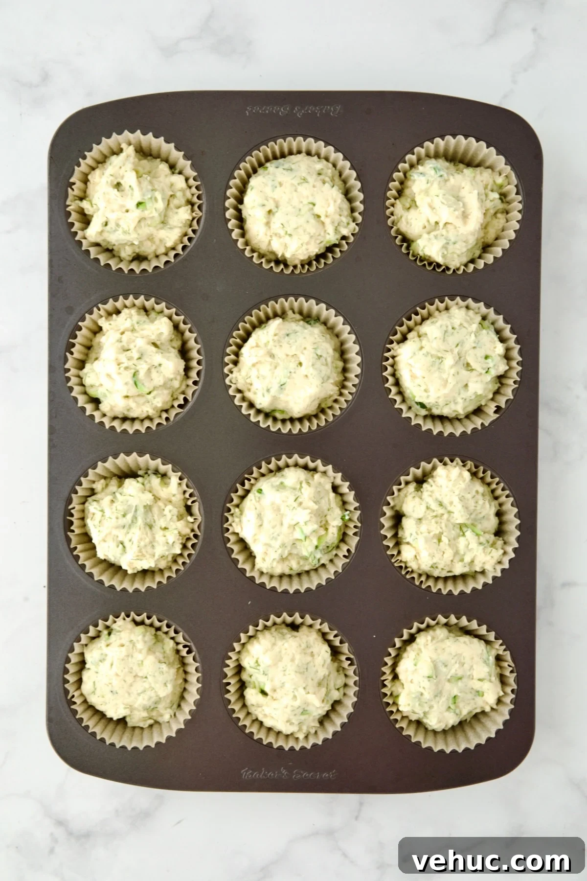 Zucchini Ricotta Dill Muffins: Savory Summer Snack 10 Batter for muffins divided into 12 paper-lined muffin cups.
