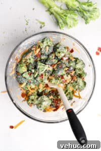 Crispy Broccoli Salad with Creamy Parmesan Dressing 20 A bowl of broccoli salad that's been mixed with a silicone spatula.