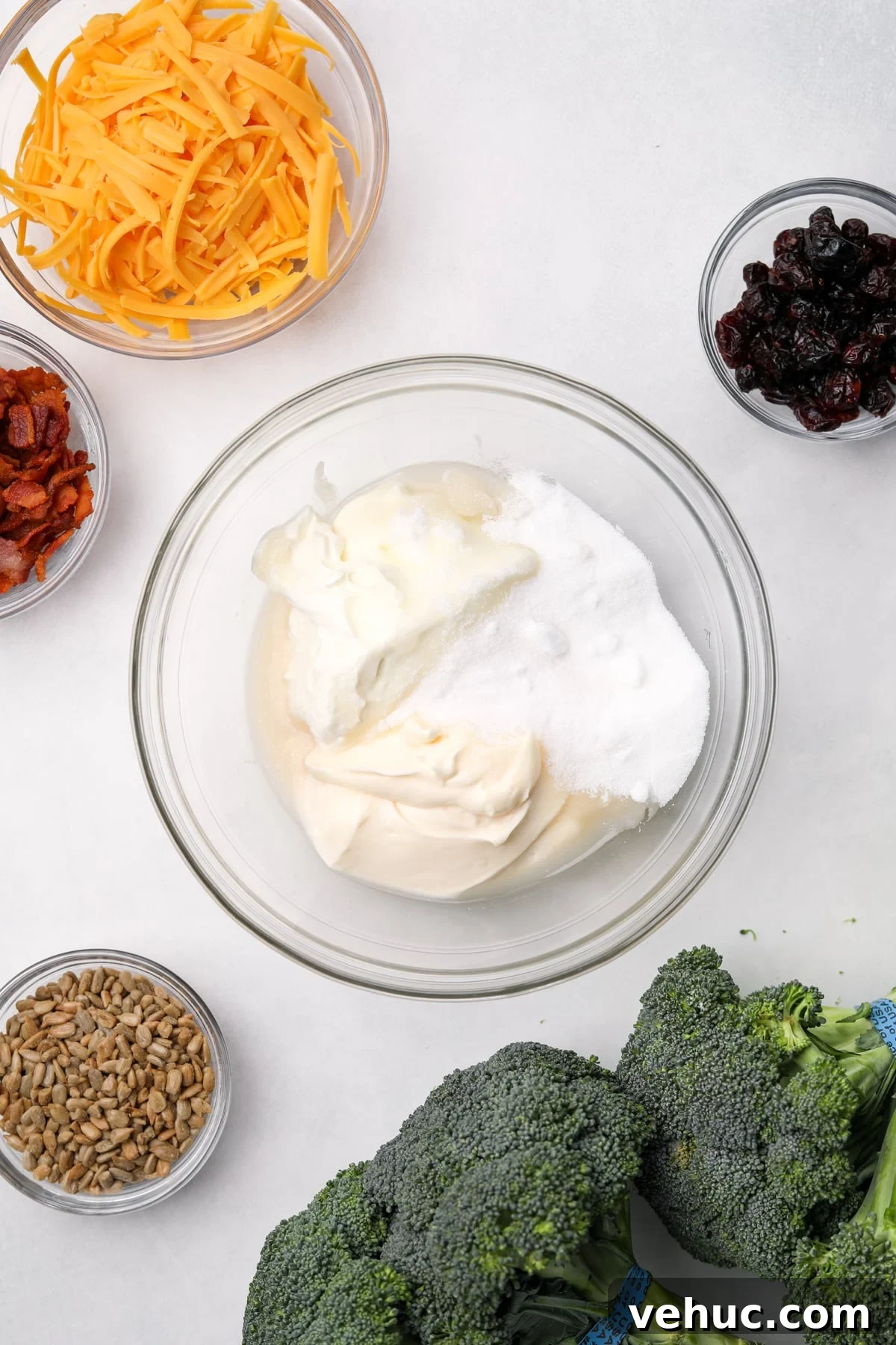Crispy Broccoli Salad with Creamy Parmesan Dressing 4 A medium bowl with a combination of sour cream, mayonnaise, and sugar in it.