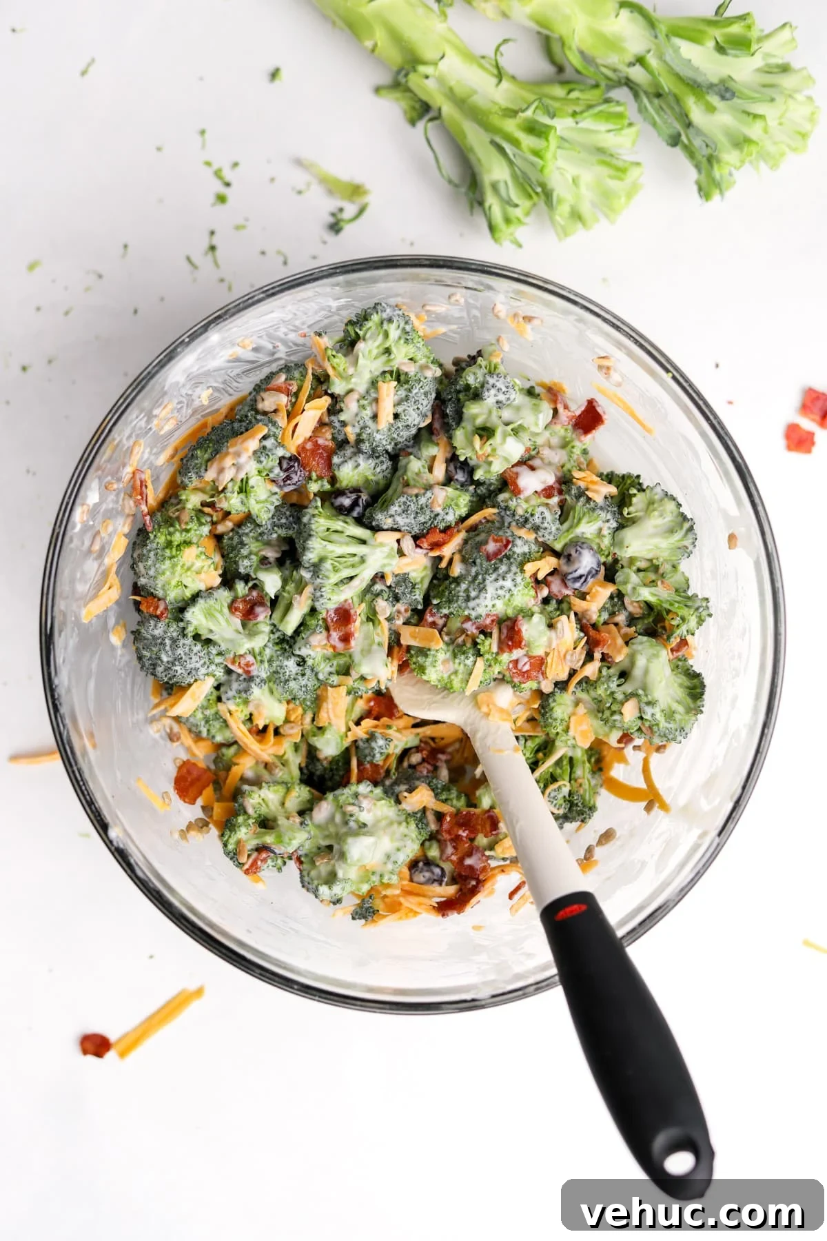 Crispy Broccoli Salad with Creamy Parmesan Dressing 10 A bowl of broccoli salad that's been mixed with a silicone spatula.