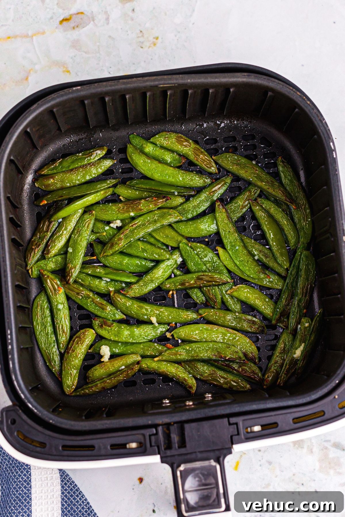 Crispy Air-Fried Sugar Snap Peas in Minutes 7 Green and juicy snap peas in the basket after being cooked in the air fryer
