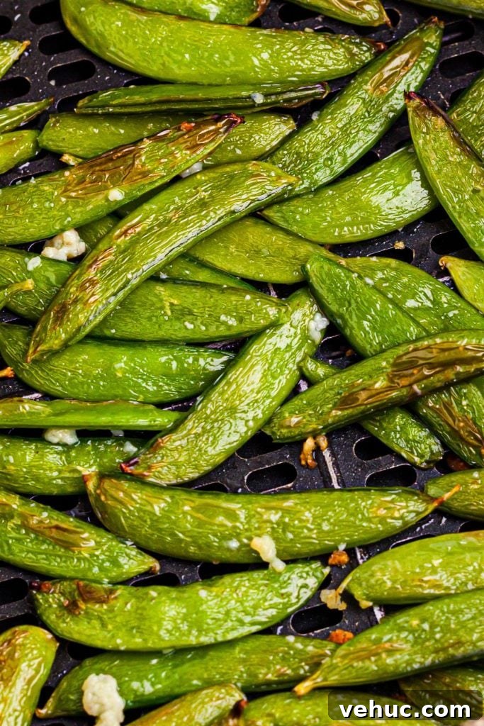 Crispy Air-Fried Sugar Snap Peas in Minutes 9 Green juicy snap peas in the air fryer basket tossed with garlic and sesame oil.