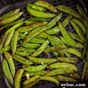 Crispy Air-Fried Sugar Snap Peas in Minutes 10 Juicy green snap peas in the air fryer basket after being cooked in the air fryer
