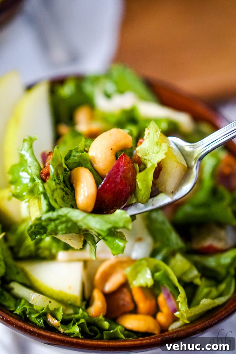 Crispy Cashew Salad with Lime Dressing: Refreshing Crunch Bowl 4 A forkful of the Cashew Nut Salad is taken from the brown bowl.
