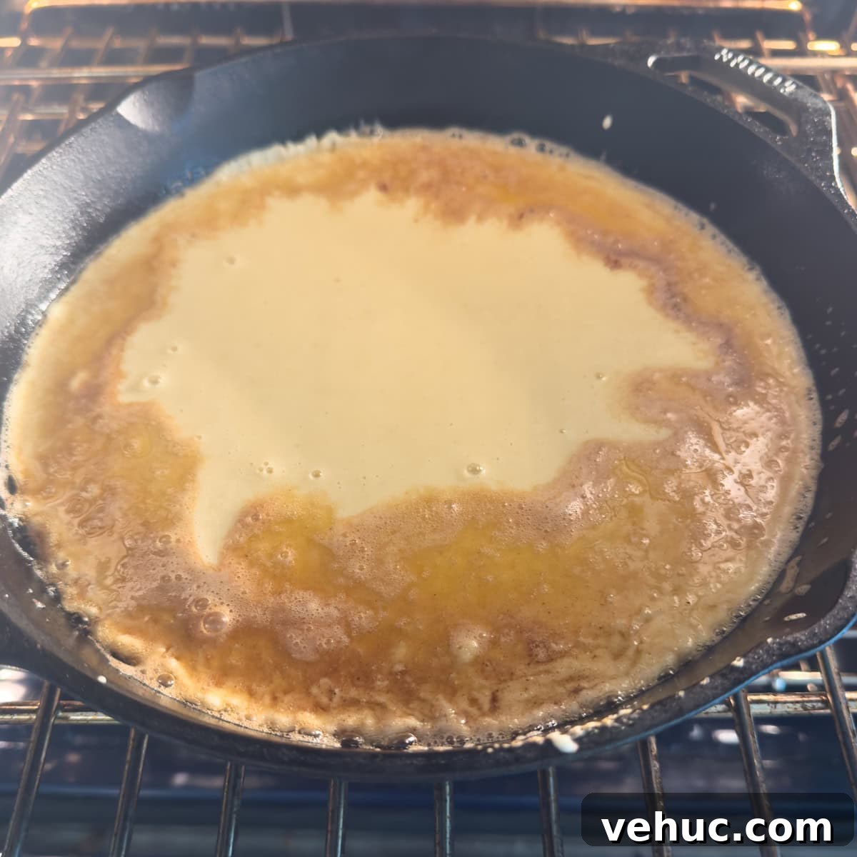 Gluten-Free Dutch Baby Pancake Recipe (German Pancake) 8 Cast iron fry pan filed with german oven pancake batter in oven.