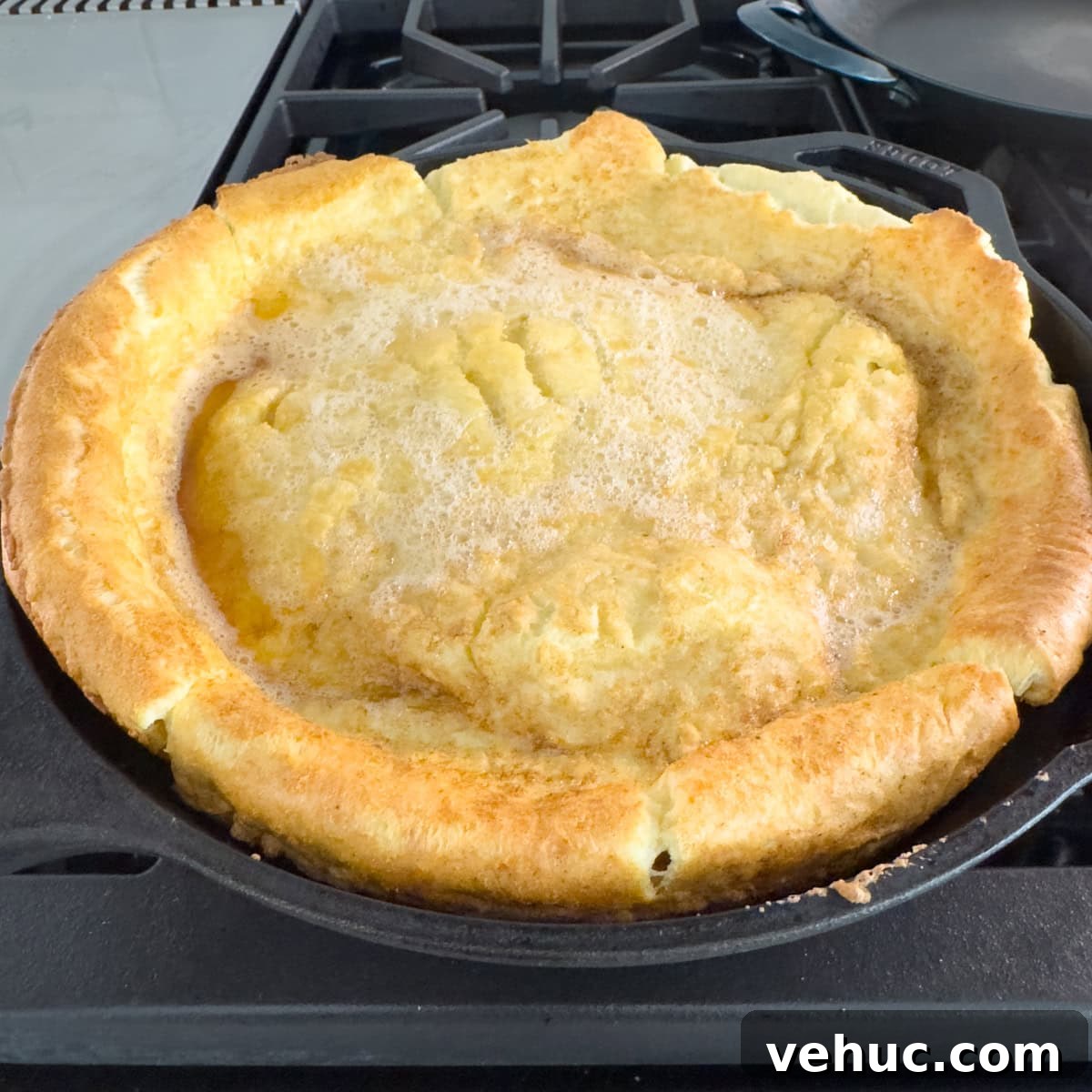 Gluten-Free Dutch Baby Pancake Recipe (German Pancake) 9 Puffed and golden dutch pancake on the stovetop, ready to eat.