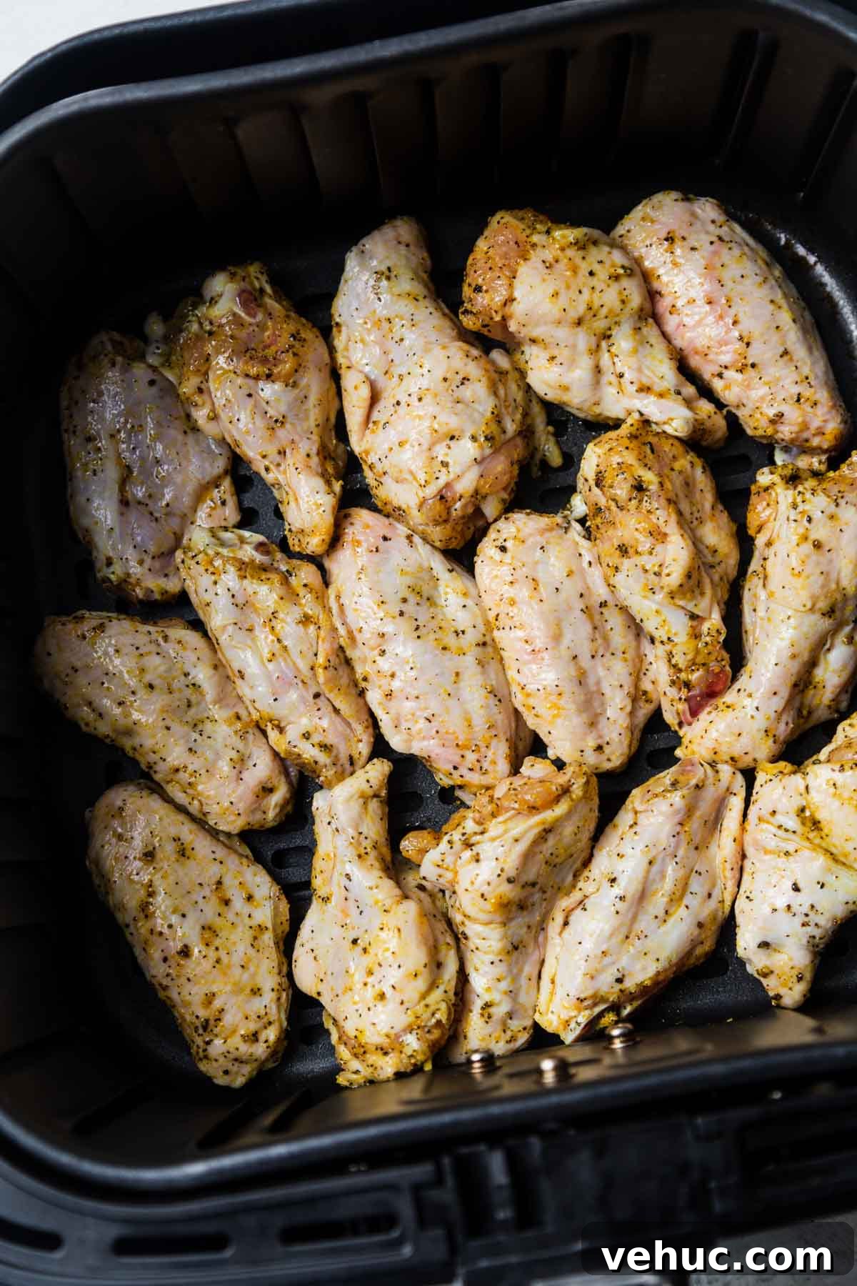 Crispy Lemon Pepper Air Fryer Chicken Wings 6 chicken wings in the air fryer basket.
