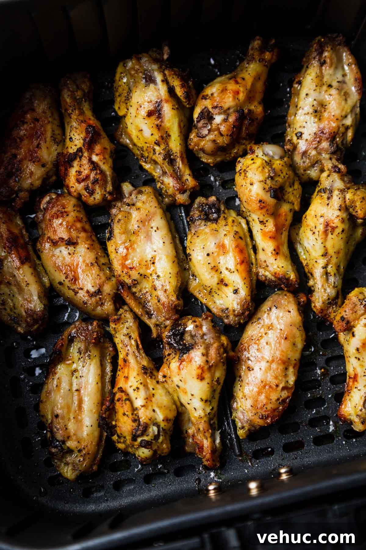 Crispy Lemon Pepper Air Fryer Chicken Wings 7 lemon pepper chicken wings in air fryer basket.