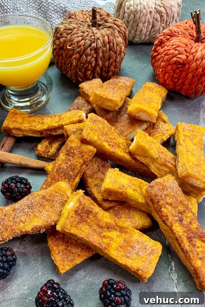 Pumpkin Churro French Toast Sticks Recipe for Fall Brunch 2 Pumpkin churro French toast sticks stacked up a garnished with blackberries.