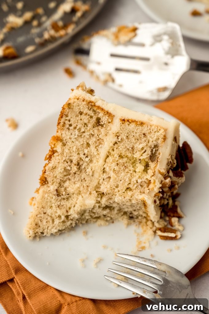 Decadent Butter Pecan Layer Cake Recipe 18 A slice of butter pecan cake on a plate with a bite taken out of it.