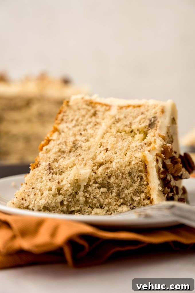Decadent Butter Pecan Layer Cake Recipe 19 A slice of butter pecan cake on a plate with a bite taken out of it.