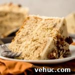 Decadent Butter Pecan Layer Cake Recipe 20 A slice of butter pecan cake on a plate with a fork.