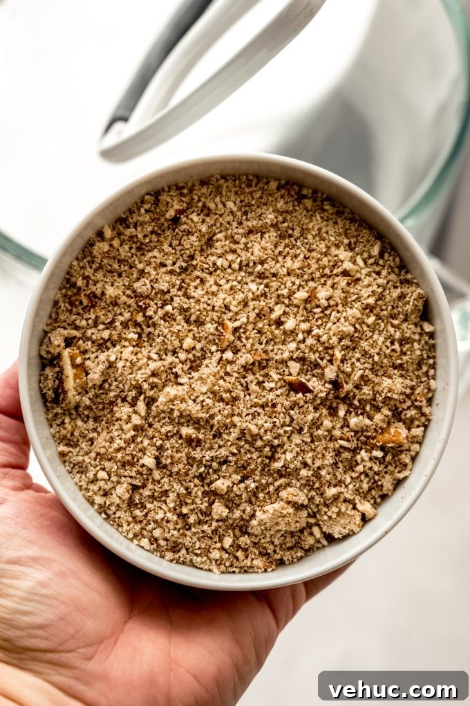 Decadent Butter Pecan Layer Cake Recipe 7 A bowl of finely chopped pecans in someone's hand.