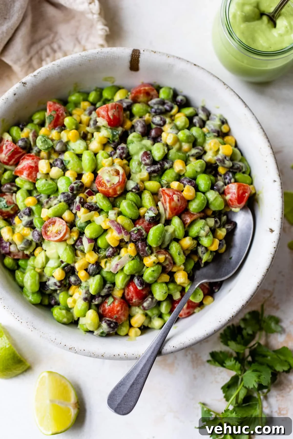 Citrus Edamame Salad with Avocado and Sesame Dressing 2 a bowl of edamame salad with a spoon
