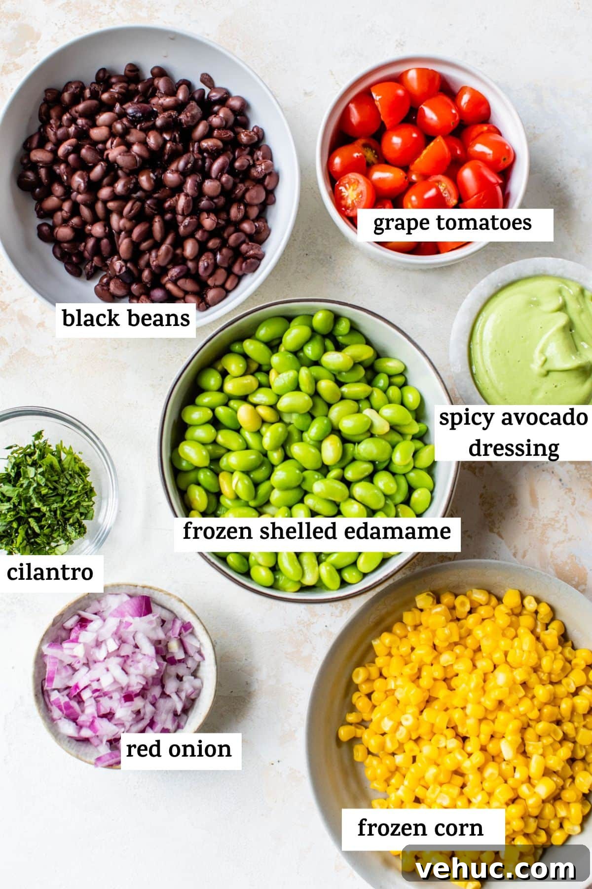 Citrus Edamame Salad with Avocado and Sesame Dressing 3 all of the ingredients for the edamame salad in bowls with text showing which ingredient is which