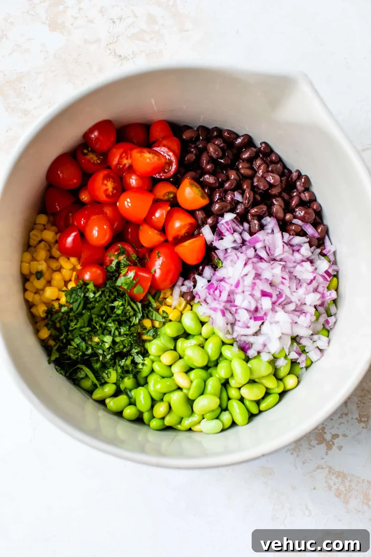 Citrus Edamame Salad with Avocado and Sesame Dressing 4 individual ingredients all separated in a large bowl