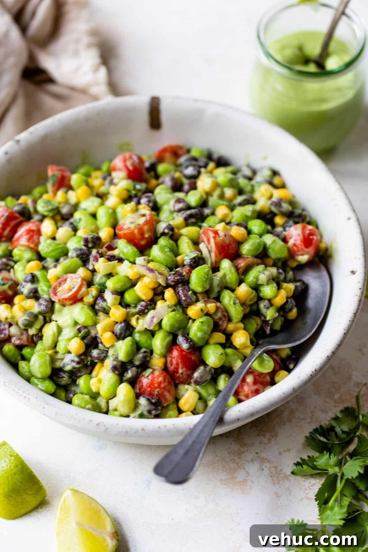 Citrus Edamame Salad with Avocado and Sesame Dressing 6 a bowl of edamame salad with a spoon