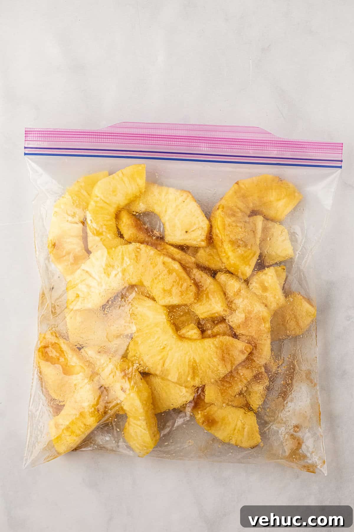 How to Grill Pineapple Perfectly: Sweet, Caramelized Slices Every Time 4 Pineapple pieces tossed in brown sugar in zip lock bag for Grilled Pineapple recipe