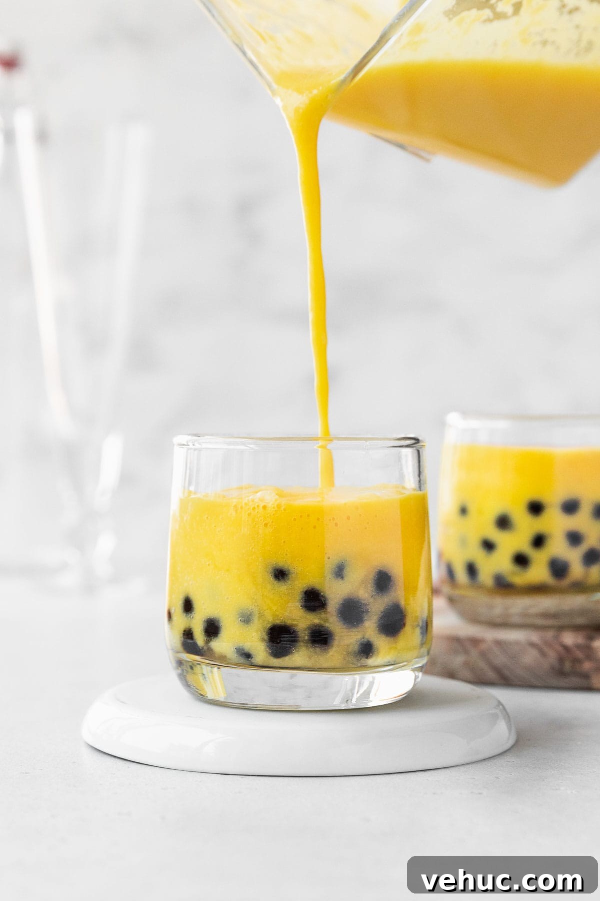 Mango Bubble Tea: Refreshing Homemade Boba Recipe 12 Filling up a small glass with mango boba tea.