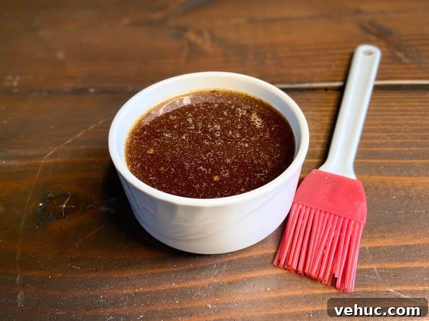 Sweet Brown Sugar Glaze for Ham: Simple Recipe for Holidays 5 Glaze in a ramekin, with a silicone brush.