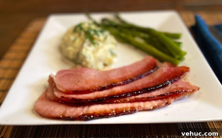 Sweet Brown Sugar Glaze for Ham: Simple Recipe for Holidays 7 Slices of ham served on a plate with vegetables.