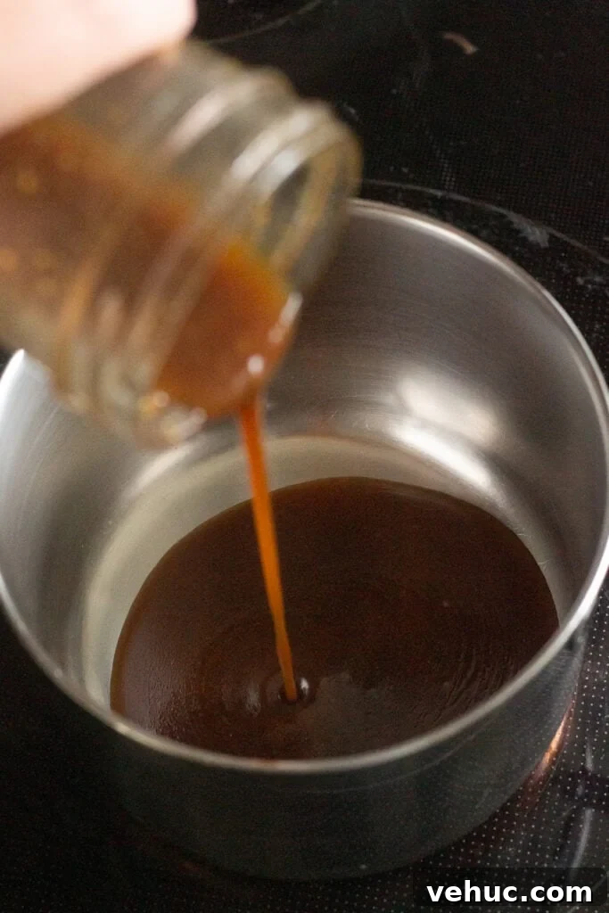 pouring a brown marinade into a small saucepan on the stove.