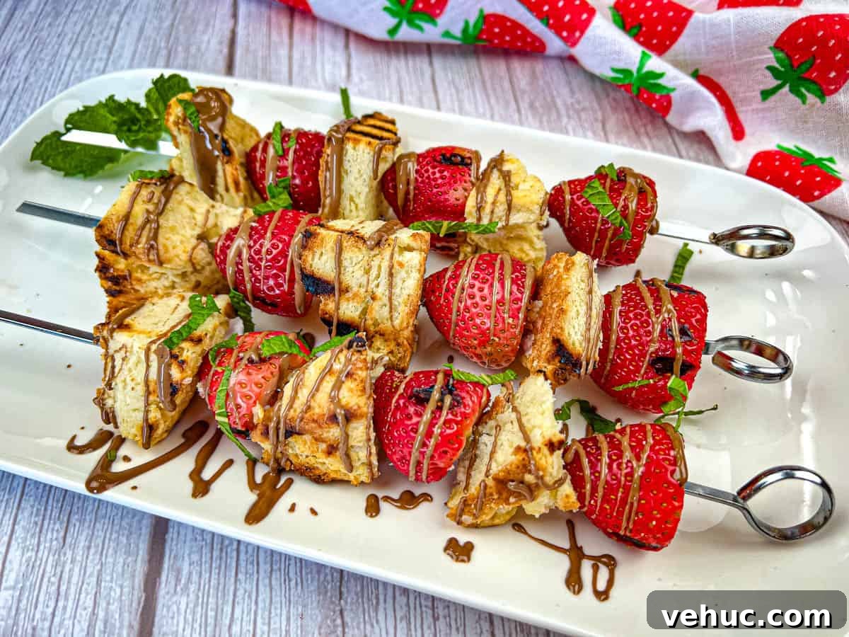 11 Strawberry Recipes That Highlight Their Sweet-Tart Flavor 6 Three pieces of Grilled Strawberry Shortcake Skewers on a white plate.