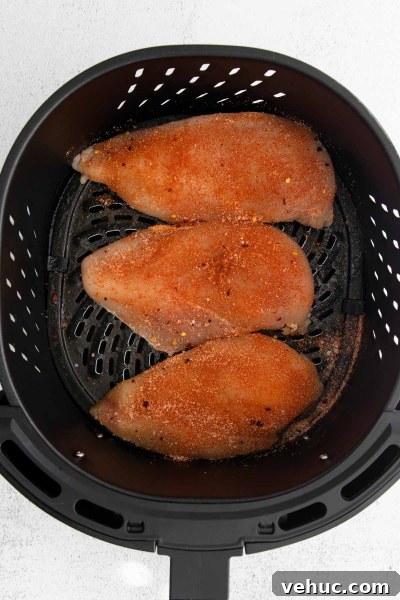 Crispy Air Fryer BBQ Chicken Recipe for Tender, Smoky Flavor 4 raw chicken breast in air fryer basket