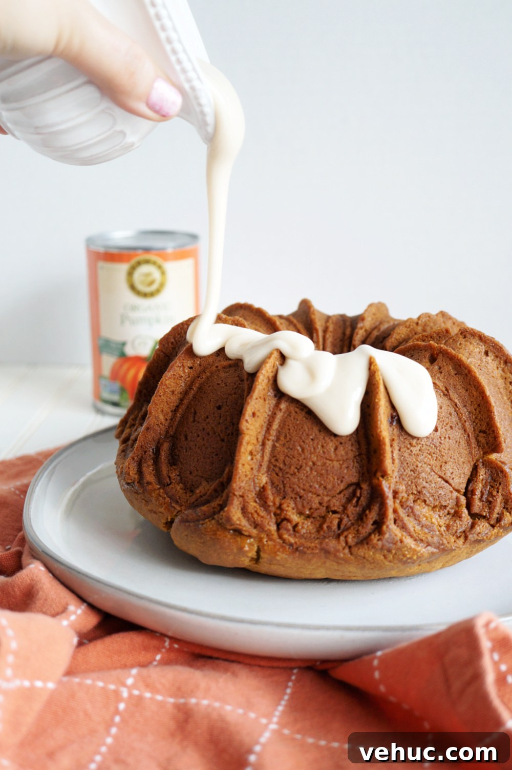 Vegan Pumpkin Spice Bundt Cake Recipe for Fall Gatherings 3 pouring glaze on pumpkin cake