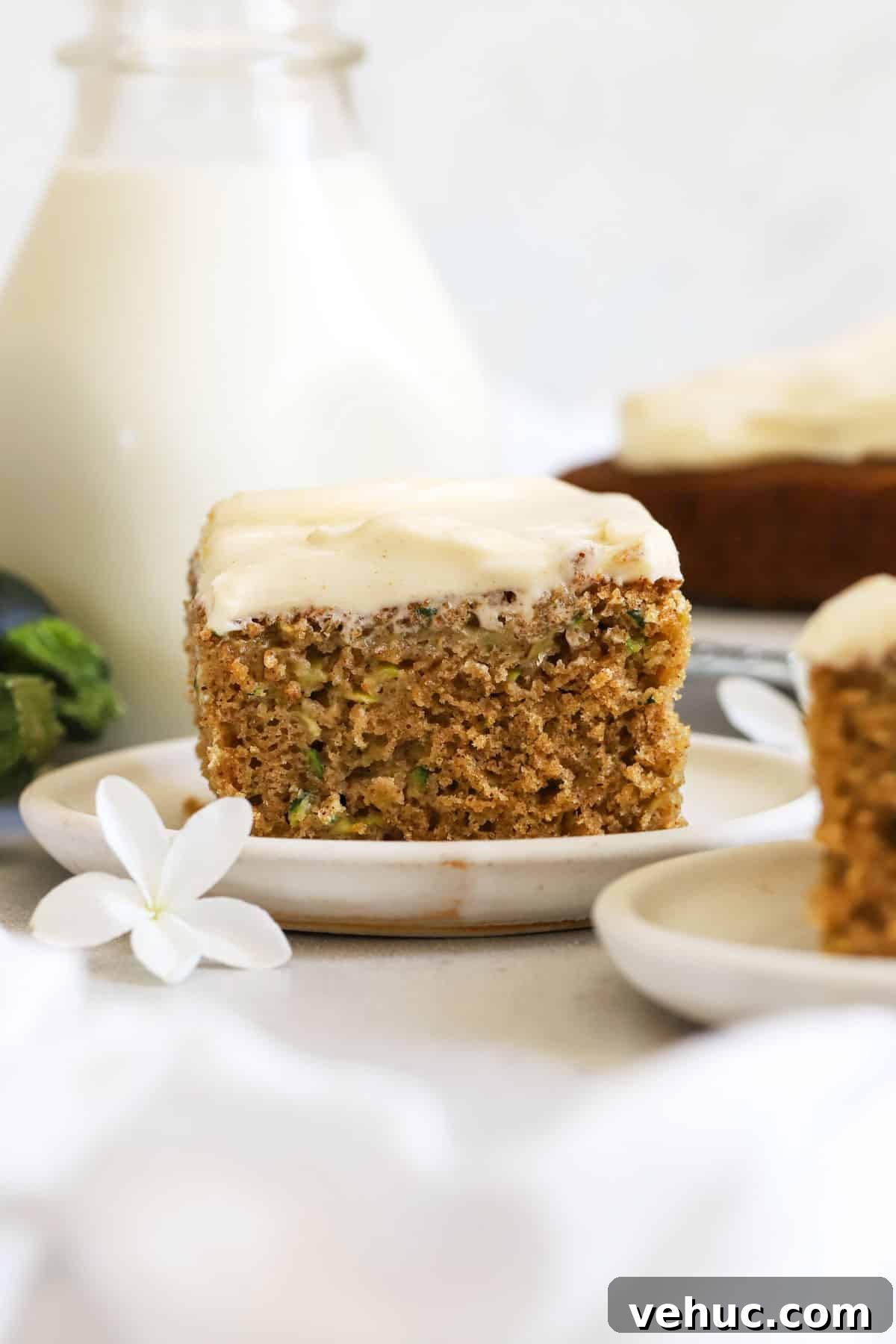Gluten-Free Zucchini Cake with Brown Butter Cream Cheese Frosting 2 slices of gluten-free zucchini cake on white dessert plate