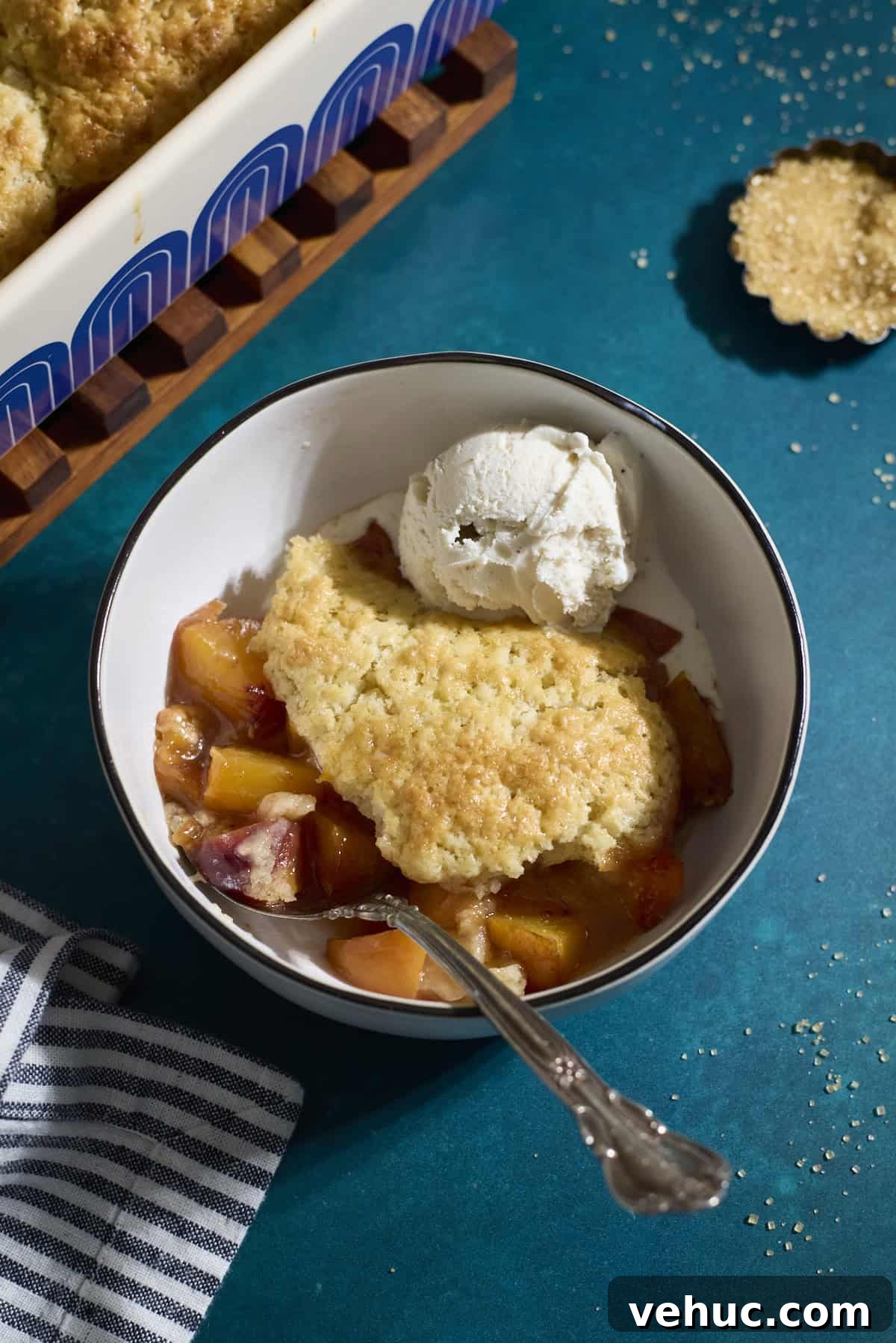 Sourdough Peach Cobbler Recipe: Rustic Peach Cobbler with Tangy Crust 2 Sourdough Peach Cobbler in a bowl with a scoop of vanilla ice cream.