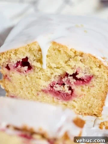 A slice of Sourdough Lemon Raspberry Loaf Cake.