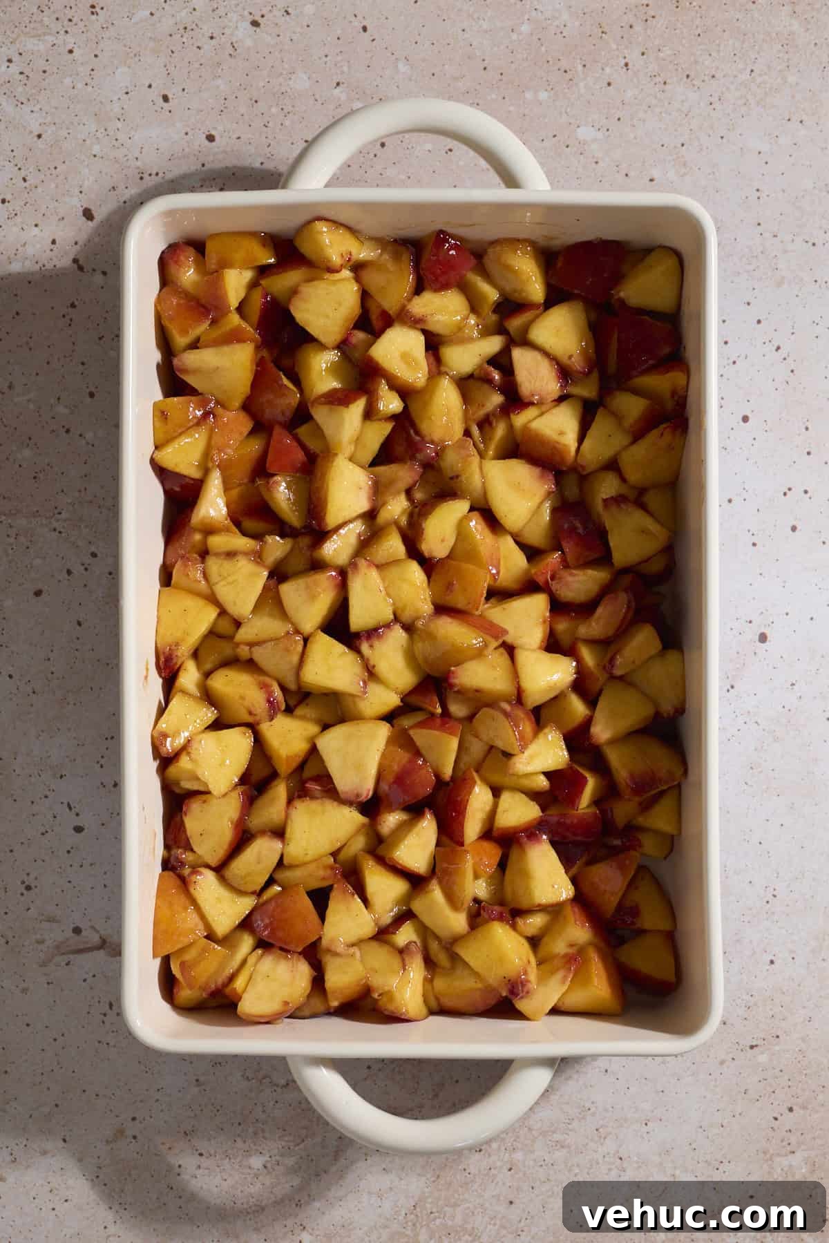 Sourdough Peach Cobbler Recipe: Rustic Peach Cobbler with Tangy Crust 6 Peaches spread in a baking dish.