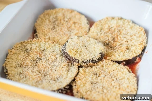 Skinny Eggplant Parmesan Recipe Layering Breaded Eggplant In Baking Dish for Eggplant Parm Lasagna