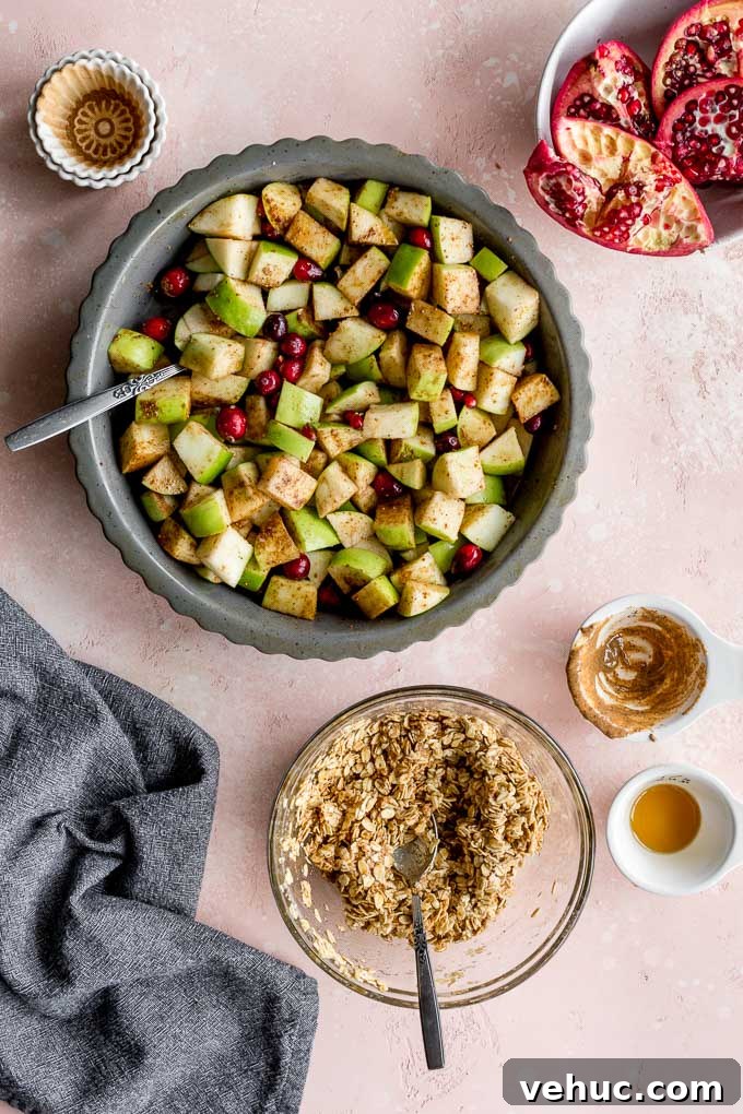 Apple Cranberry Crisp: Gluten-Free Vegan Recipe for Fall Dessert 5 Ingredients for the apple filling in a pie plate with a bowl of the crisp topping off to the side.