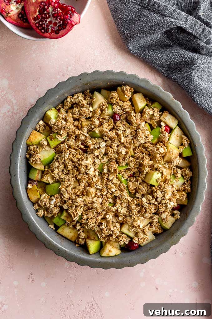 Apple Cranberry Crisp: Gluten-Free Vegan Recipe for Fall Dessert 6 Apple cranberry crisp topped with oat mixture and ready for the oven.