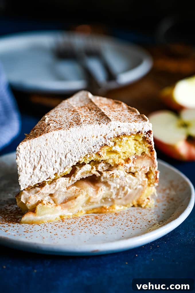Apple Piecaken, you ask? I’ve baked an entire apple pie inside a yellow cake and frosted with my Cinnamon Cool Whip Frosting for a one of a kind dessert. A slice of Apple Piecaken on a white plate, dusted with cinnamon.