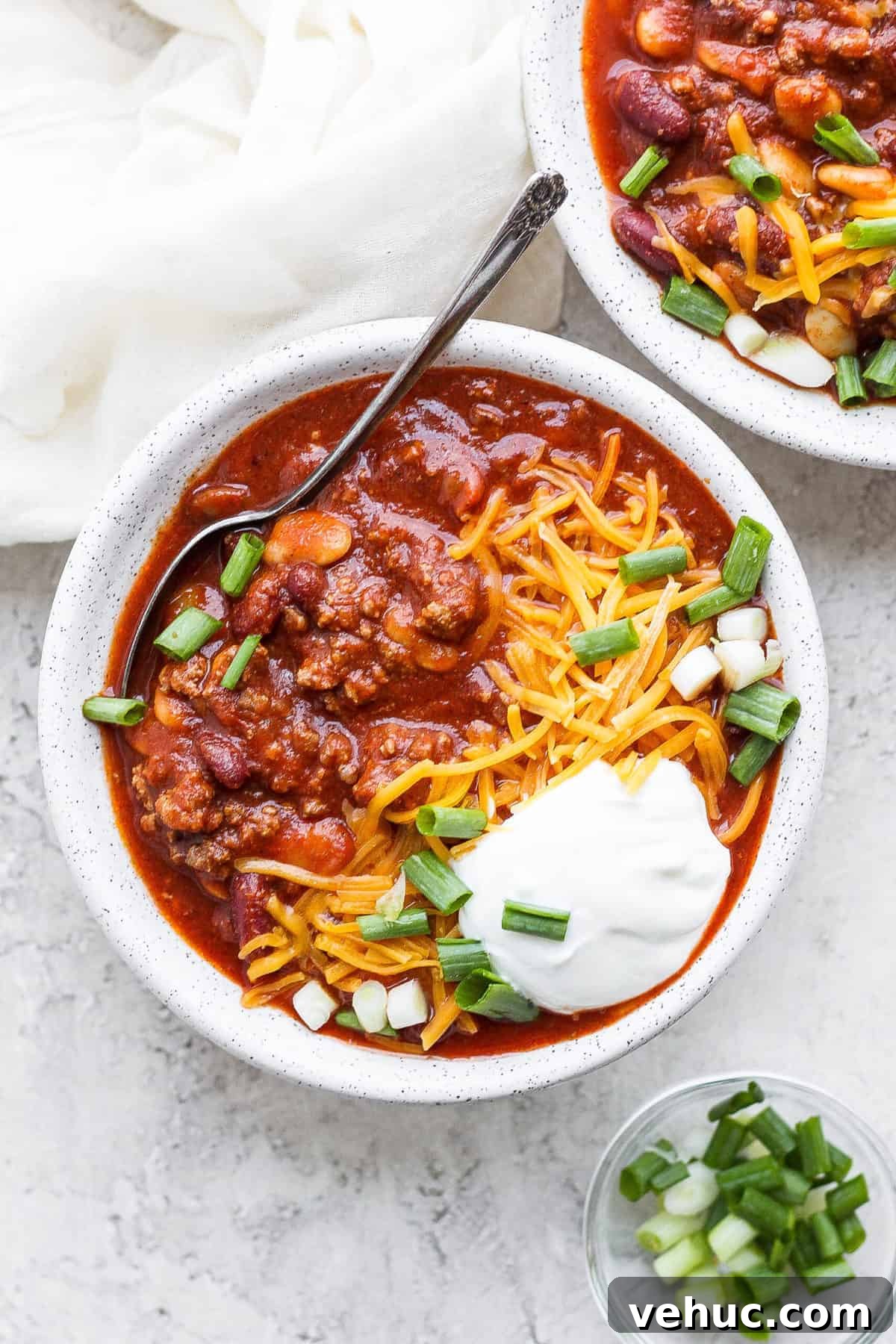 Slow cooker chili in a bowl with a spoon.