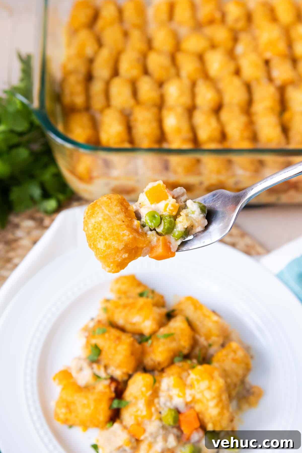 Cheesy Ground Turkey Tater Tot Casserole Recipe 10 A forkful of Turkey Tater Tot Casserole to show the ground turkey, peas, and carrots in a creamy sauce.