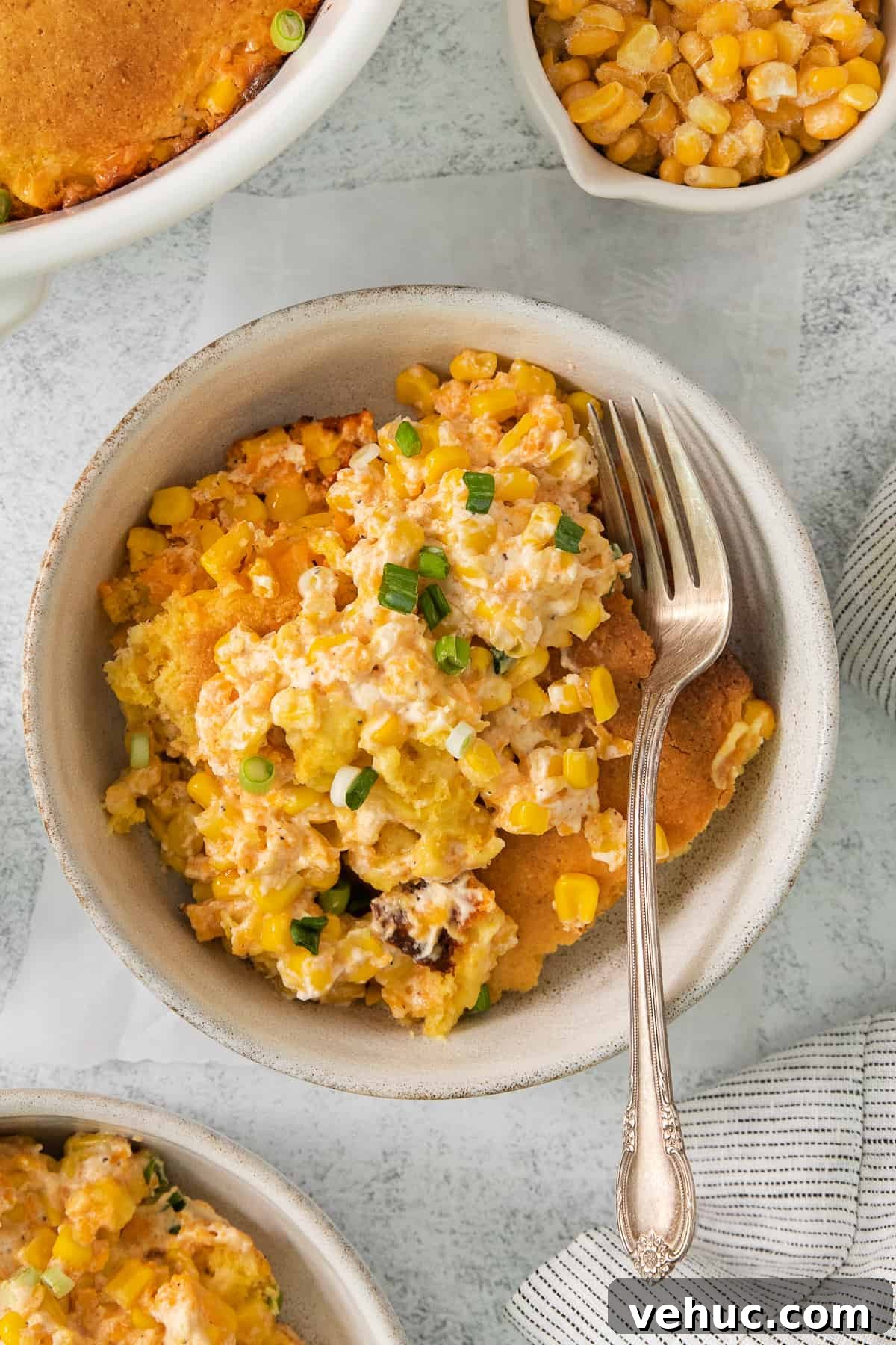 Creamy Cheddar Corn Casserole Recipe for Comforting Sides 2 a bowl of corn casserole with a fork in it.