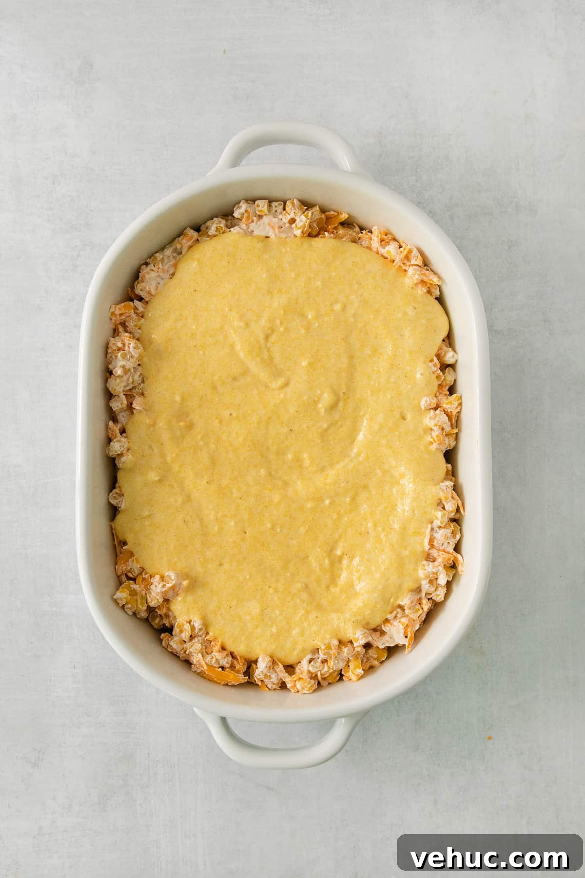 Creamy Cheddar Corn Casserole Recipe for Comforting Sides 6 a casserole dish filled with a mixture of cheese.