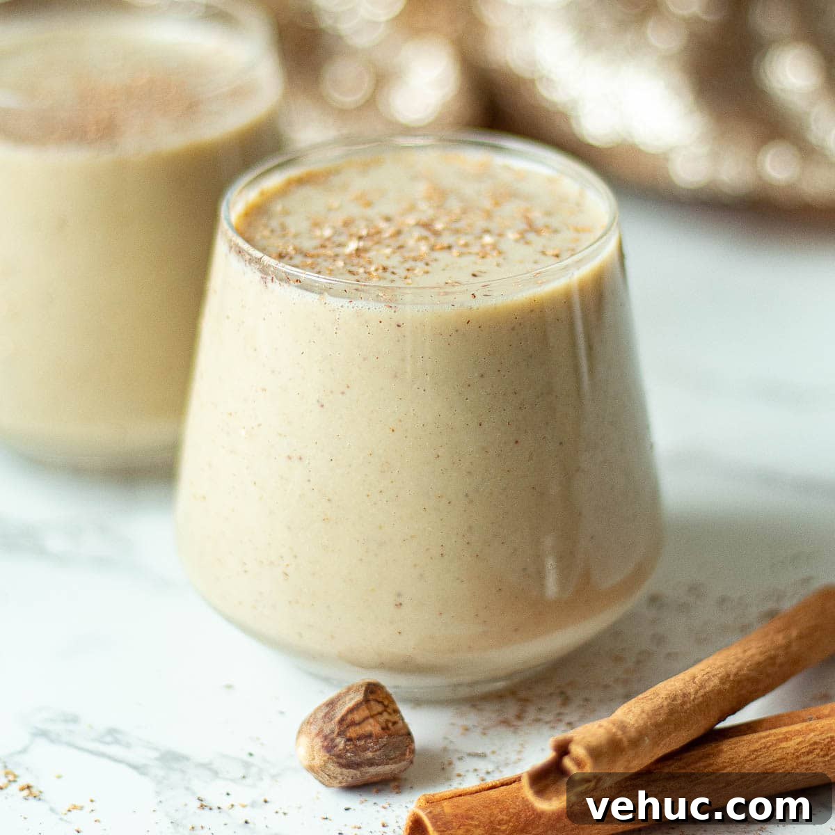Creamy Oat Milk Eggnog Recipe for Holiday Parties 2 oat milk eggnog recipe in classes with grated nutmeg
