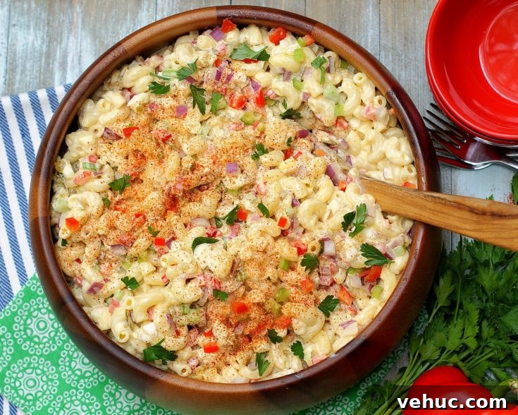 An aerial view of Southern Macaroni Salad bursting with red bell pepper, celery, red onion, sweet pickles and eggs.