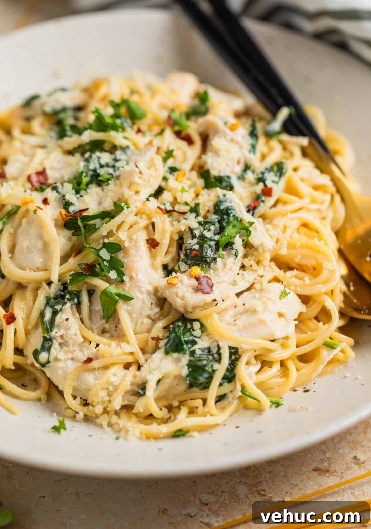 Creamy Parmesan Chicken in the Instant Pot: Quick Weeknight Meal 2 Instant pot creamy parmesan chicken tossed with pasta on plate and topped with chopped parsley and red pepper flakes.