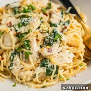 Creamy Parmesan Chicken in the Instant Pot: Quick Weeknight Meal 9 Instant pot creamy parmesan chicken tossed with pasta on plate with utensils.