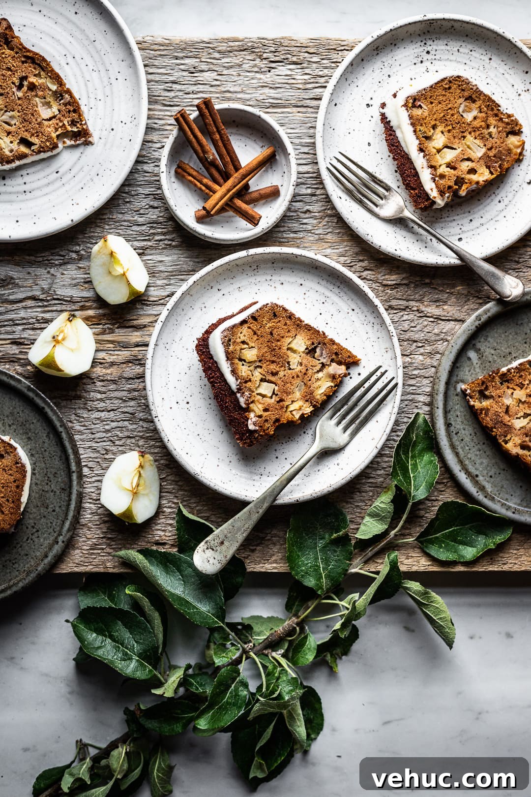 Moist Applesauce Bundt Cake Recipe for Fall Baking 3 Slices of apple bundt cake on plates with forks, cinnamon sticks and apple slices as decoration