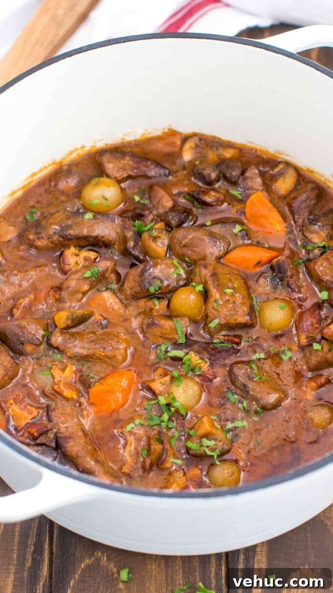 Classic Beef Bourguignon Recipe: Tender Braised Beef in Red Wine 3 a Dutch oven of homemade Beef Bourguignon with pearl onions, and carrots