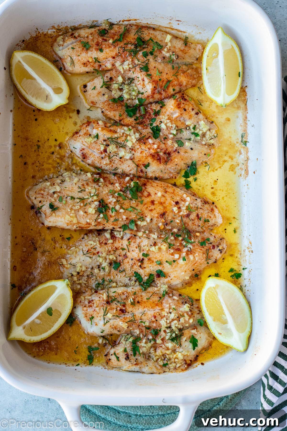 Garlic Butter Tilapia Recipe with Lemon and Herbs 8 Baked tilapia fillets in baking dish.