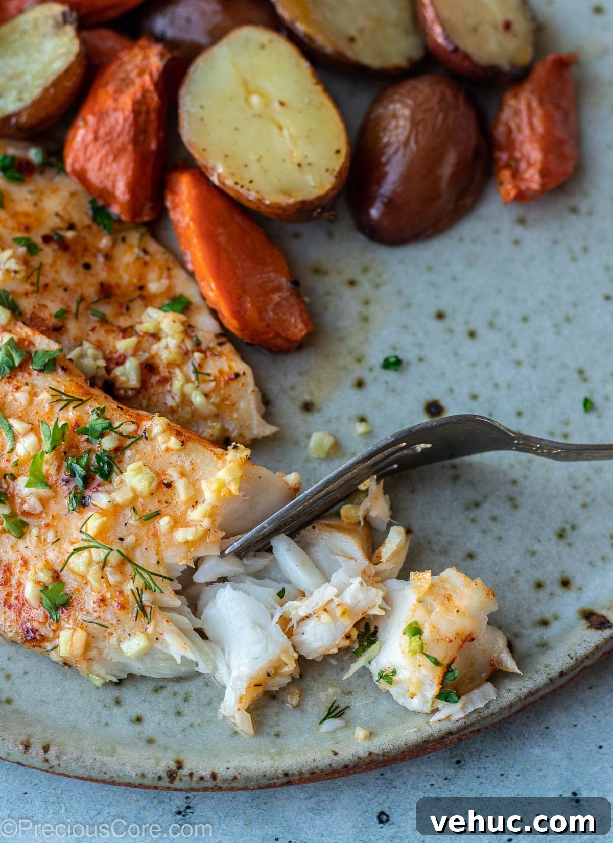 Garlic Butter Tilapia Recipe with Lemon and Herbs 9 Flaky fish on a plate.