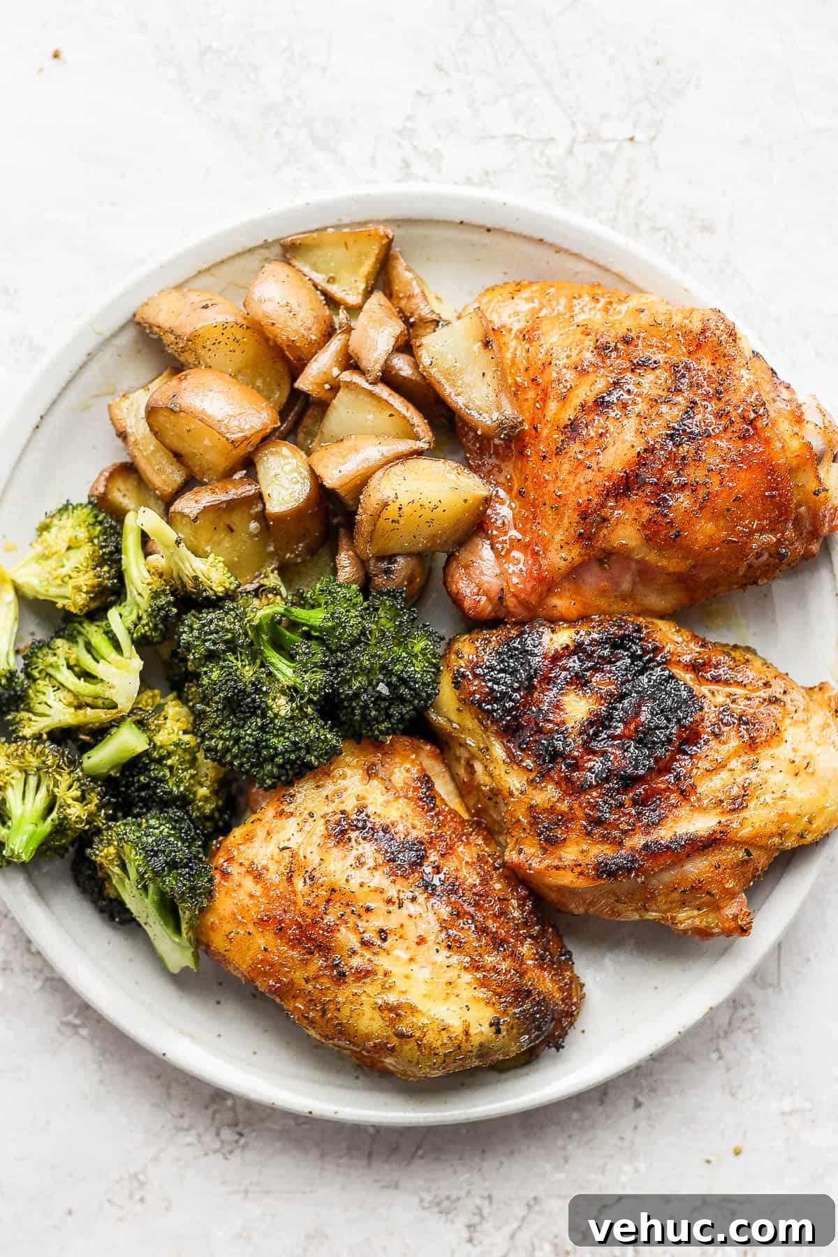 A plate of smoked chicken thighs, smoked broccoli and smoked potatoes. 